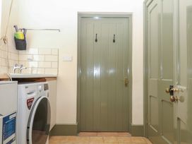 A laundry room with a washing machine and sink at Lukesland Wing in Ivybridge