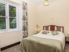 A bedroom with a bed and window at Lukesland Wing in Ivybridge
