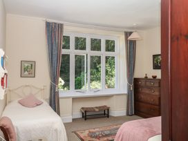 A bedroom with two beds and a window at Lukesland Wing Ivybridge