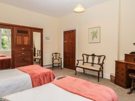 A bedroom with two beds and a wardrobe at Lukesland Wing in Ivybridge