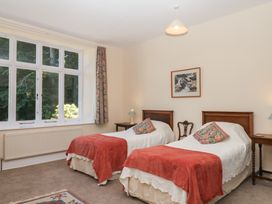 A bedroom with two beds and a window at Lukesland Wing in Ivybridge