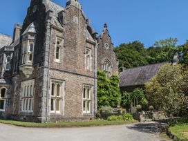 A stone building with windows and greenery at Lukesland Wing in Ivybridge