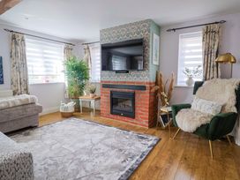 A living room with a fireplace and television at The Coach House Dorchester