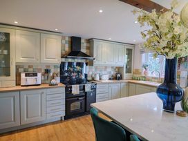 A kitchen with cabinets and a stove at The Coach House in Dorchester