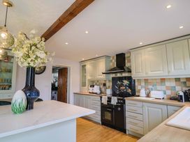 A kitchen with cabinets, stove and countertop at The Coach House in Dorchester