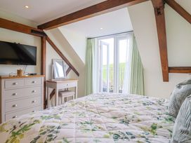 A bedroom with a bed and television at The Coach House in Dorchester