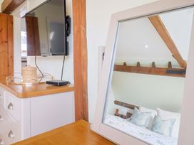 A bedroom with a television and mirror at The Coach House in Dorchester