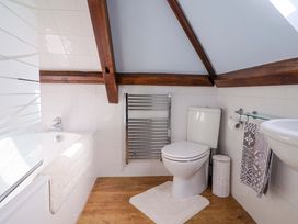 A bathroom with a shower, bathtub, toilet, towel rail, and sink at The Coach House in Dorchester