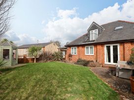 A garden with grass and a sitting area at The Coach House in Dorchester
