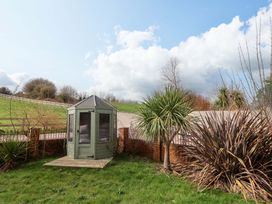 A gazebo in a garden with palm trees at The Coach House in Dorchester