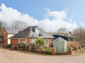 An outdoor view of a house with a shed and garden at The Coach House in Dorchester