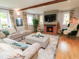 A living room with a fireplace and television at The Coach House near Charminster