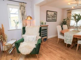 A living room with a green sofa chair and wine rack at The Coach House Near Charminster