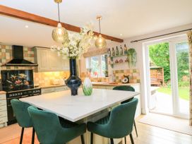 A kitchen with an island and stools at The Coach House near Charminster