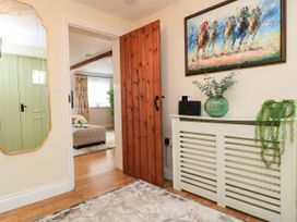 A hallway featuring a wooden door and a mirror at The Coach House Near Charminster