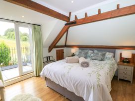 A bedroom with a bed, bedside tables, and a view at The Coach House near Charminster