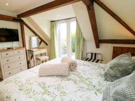 A bedroom with a bed and furniture at The Coach House near Charminster