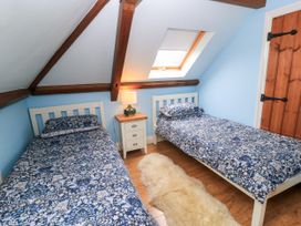 A bedroom with two beds and a nightstand at The Coach House Near Charminster