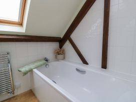 A bathroom with a bathtub and a window at The Coach House near Charminster