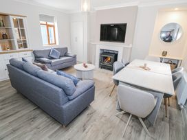 A living room with a sofa, dining table, and fireplace at Ballina in Inverin