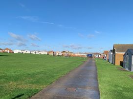 An outdoor area with a pathway and holiday cabins at Salt Air 130 @ Park Ave Holiday Village, Leysdown-On-Sea, Kent