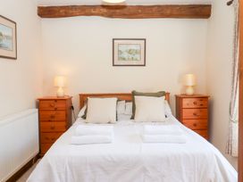 A bedroom with a bed and bedside tables at The Cottage in Sampford Courtenay