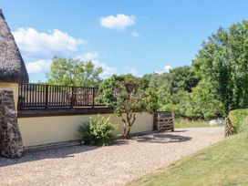 An outdoor area with a thatched roof and gravel path at The Cottage in Sampford Courtenay