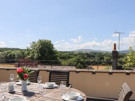 An outdoor dining area with a table and chairs at The Cottage in Sampford Courtenay