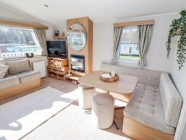 A living room with a sofa and a table at 75 Morpeth Mews in Wooler
