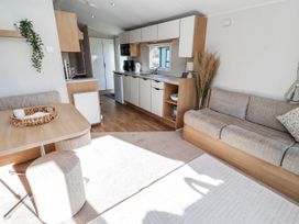 A living room with a sofa and table at 75 Morpeth Mews Wooler