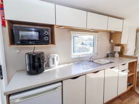 A kitchen with a microwave and kettle at 75 Morpeth Mews in Wooler