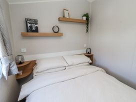 A bedroom with a bed and shelves at 75 Morpeth Mews Wooler