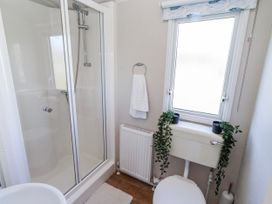 A bathroom with a shower, toilet, and sink at 75 Morpeth Mews Wooler