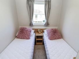 A bedroom with two single beds and a table at 75 Morpeth Mews Wooler