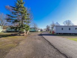 An outdoor area with caravans and a tree at 75 Morpeth Mews Wooler