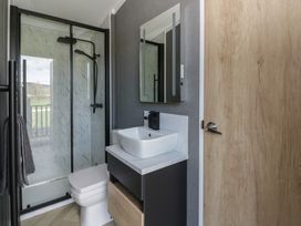 A bathroom with a shower, toilet, and sink at Dawn's Rest Nantmel near Rhayader