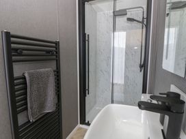 A bathroom with a shower and sink at Dawn's Rest Nantmel near Rhayader