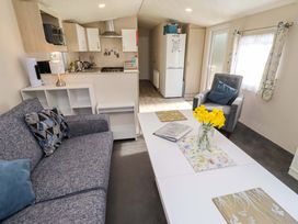 A living room with a sofa and coffee table at Gardeners Lodge