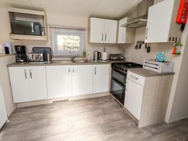 A kitchen with various appliances and cabinets at Gardeners Lodge 