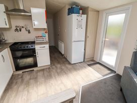 A kitchen with appliances and door to the outside at Gardeners Lodge