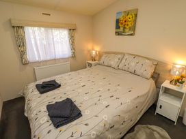 A bedroom with a bed and two bedside tables at Gardeners Lodge