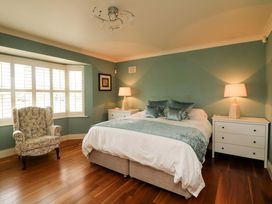 A bedroom with a bed, armchair, and nightstands at Sunnyside in River Chapel