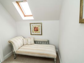A chaise longue with cushions and framed artwork at Sunnyside in River Chapel