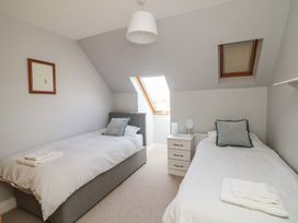 A bedroom with two beds and a window at Sunnyside, River Chapel near Courtown, County Wexford