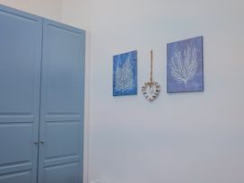 A room with a wardrobe and wall art at Le Petit Glen in Uplyme