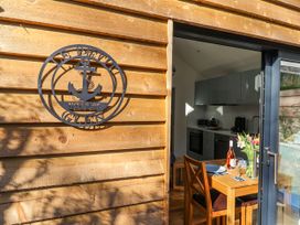 A kitchen with a wooden wall and dining table at Le Petit Glen in Uplyme