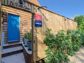 A wooden entrance with a blue door and signage at Le Petit Glen in Uplyme