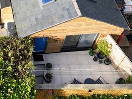 A patio area with plants and outdoor furniture at Le Petit Glen in Uplyme