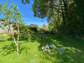A garden with trees and flowers at Le Petit Glen in Uplyme