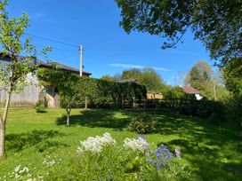 A garden with trees and flowers at Le Petit Glen in Uplyme